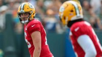 Green Bay Packers quarterback Sean Clifford (16) looks over to Malik Willis (2) in a drill during practice