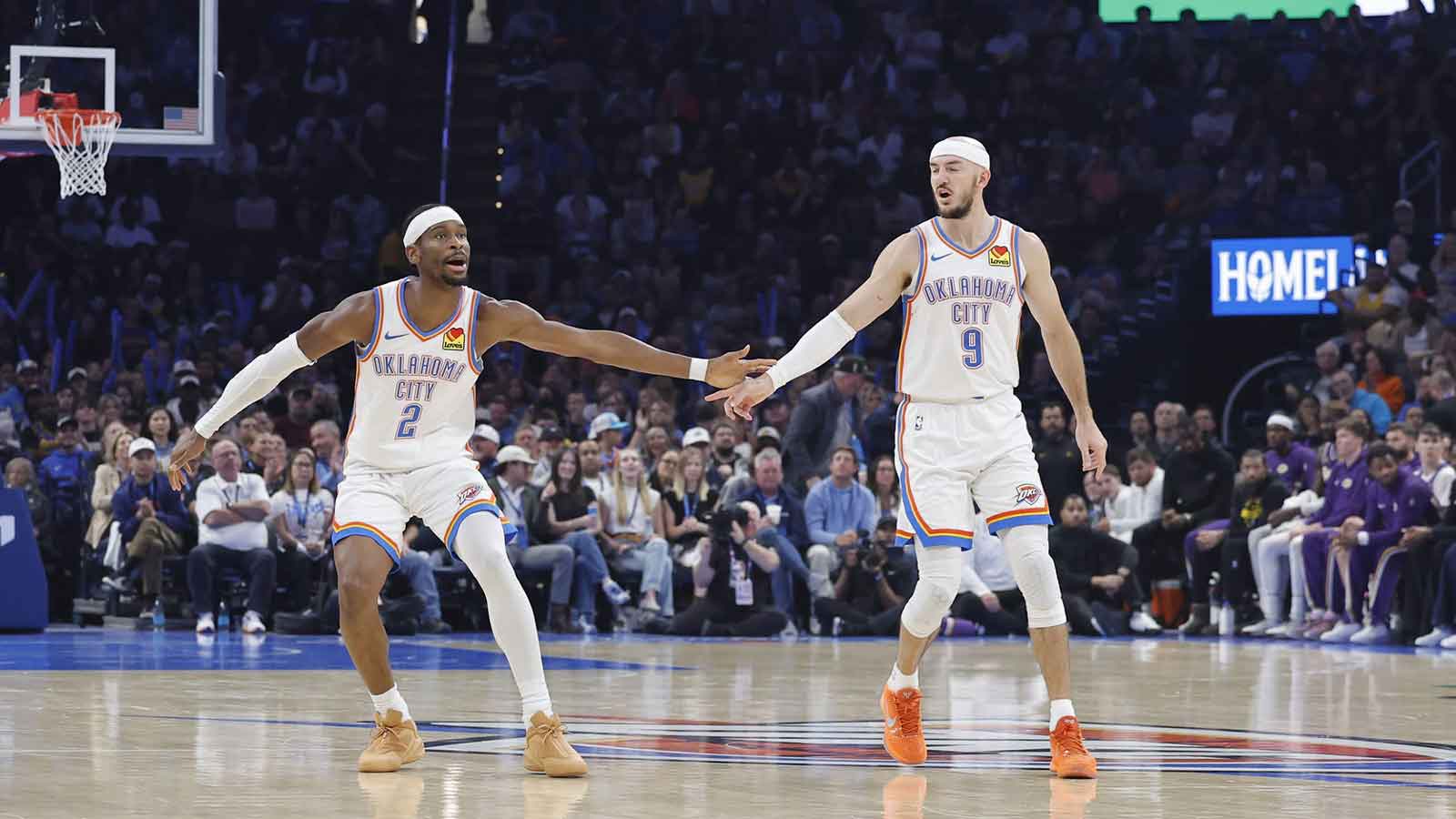 Oklahoma City Thunder guard Shai Gilgeous-Alexander (2) and Oklahoma City Thunder guard Alex Caruso (9) celebrate after a basket against the Los Angeles Lakers during the second quarter at Paycom Center.