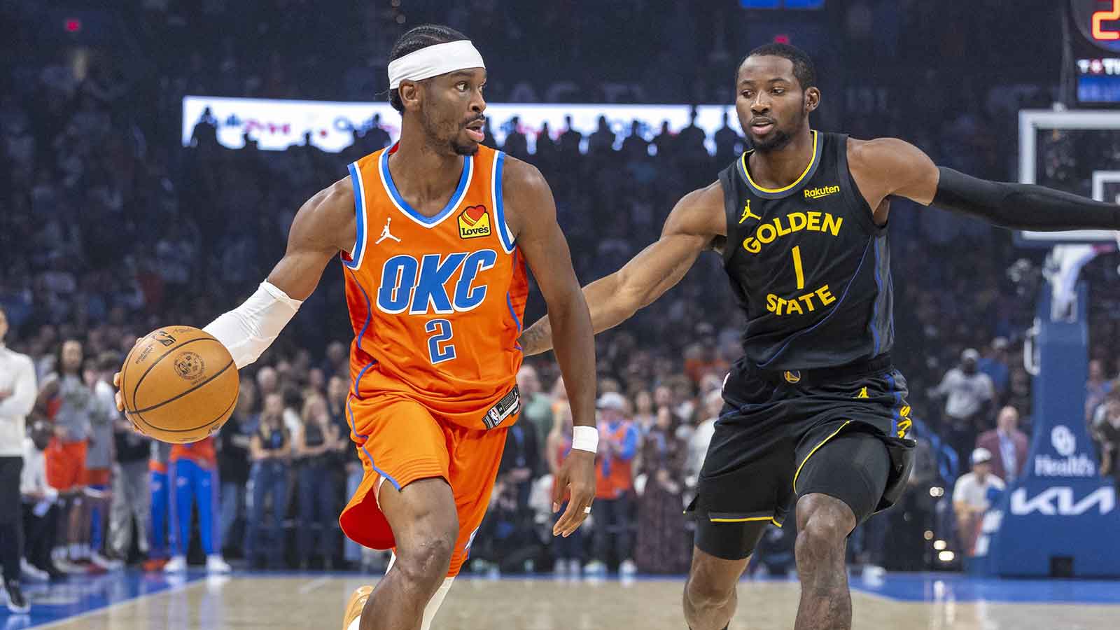 Oklahoma City Thunder guard Shai Gilgeous-Alexander (2) moves the ball down the court beside Golden State Warriors forward Jonathan Kuminga (1) during the first quarter at Paycom Center.