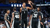 San Antonio Spurs forward Victor Wembanyama (1) celebrates with San Antonio Spurs forward Julian Champagnie (30) and San Antonio Spurs guard Stephon Castle (5) and San Antonio Spurs forward Harrison Barnes (40) during the second half against the Dallas Mavericks at American Airlines Center.