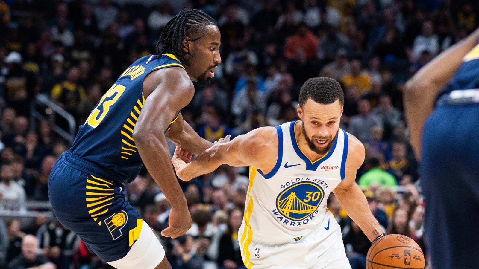 Golden State Warriors guard Stephen Curry (30) dribbles the ball while Indiana Pacers guard/forward Aaron Nesmith (23) defends in the first half at Gainbridge Fieldhouse