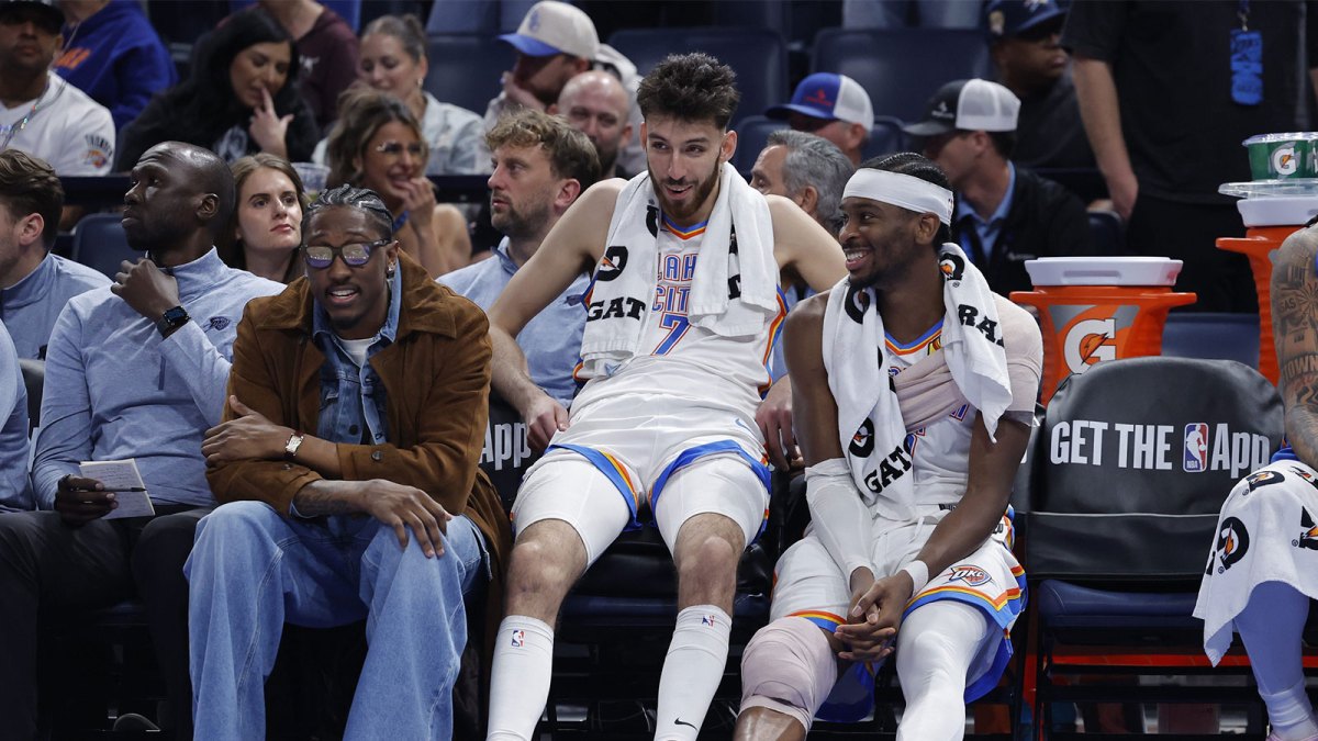 Thunder guard Jalen Williams (8), center Chet Holmgren (7), and guard Shai Gilgeous-Alexander (2) talk while sitting on the bench during the fourth quarter against the Los Angeles Lakers at Paycom Center with Chris Mannix in the background
