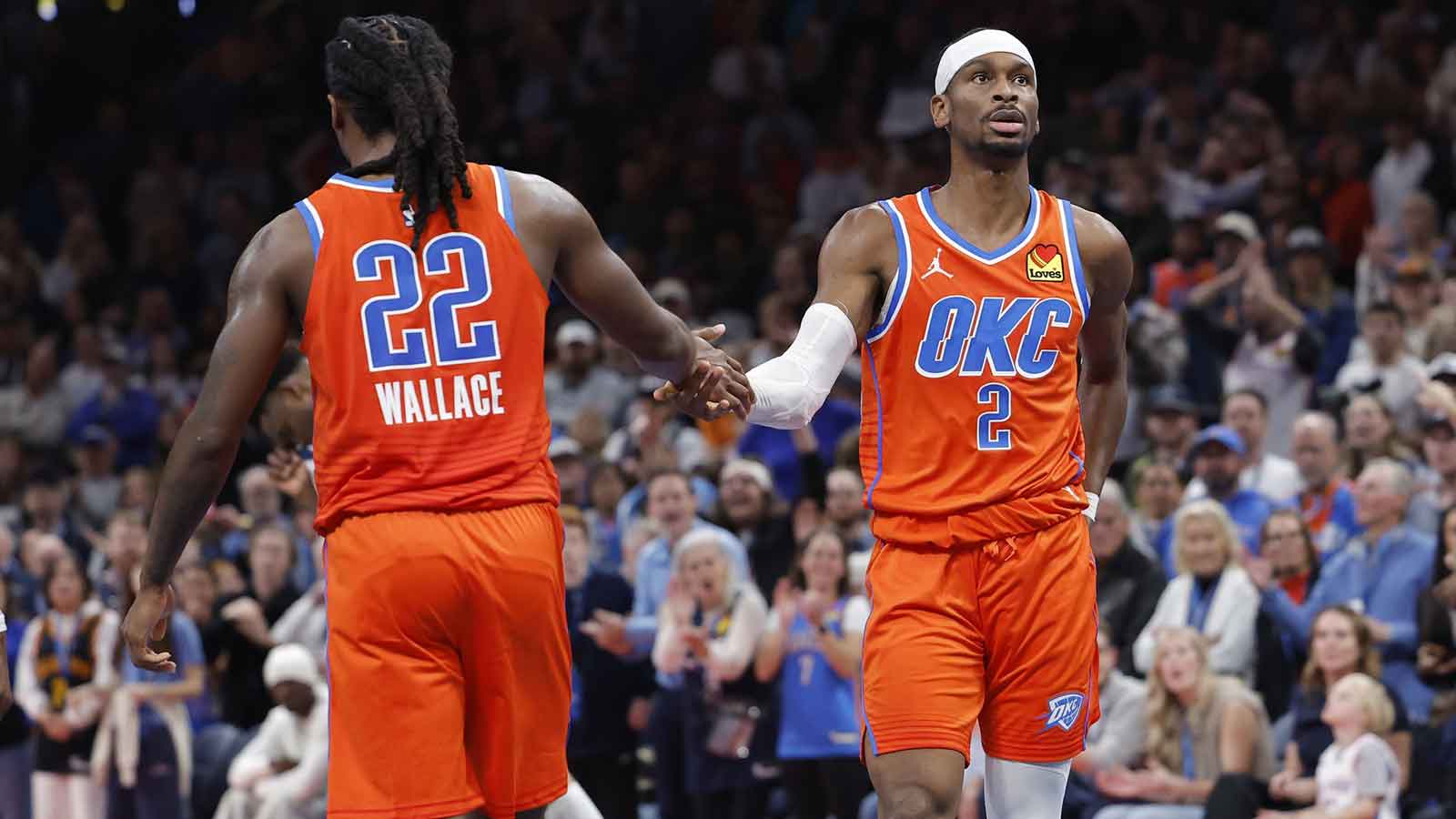 Thunder guard Shai Gilgeous-Alexander (2) high fives Oklahoma City Thunder guard Cason Wallace (22) after a play against the Minnesota Timberwolves during the second half at Paycom Center