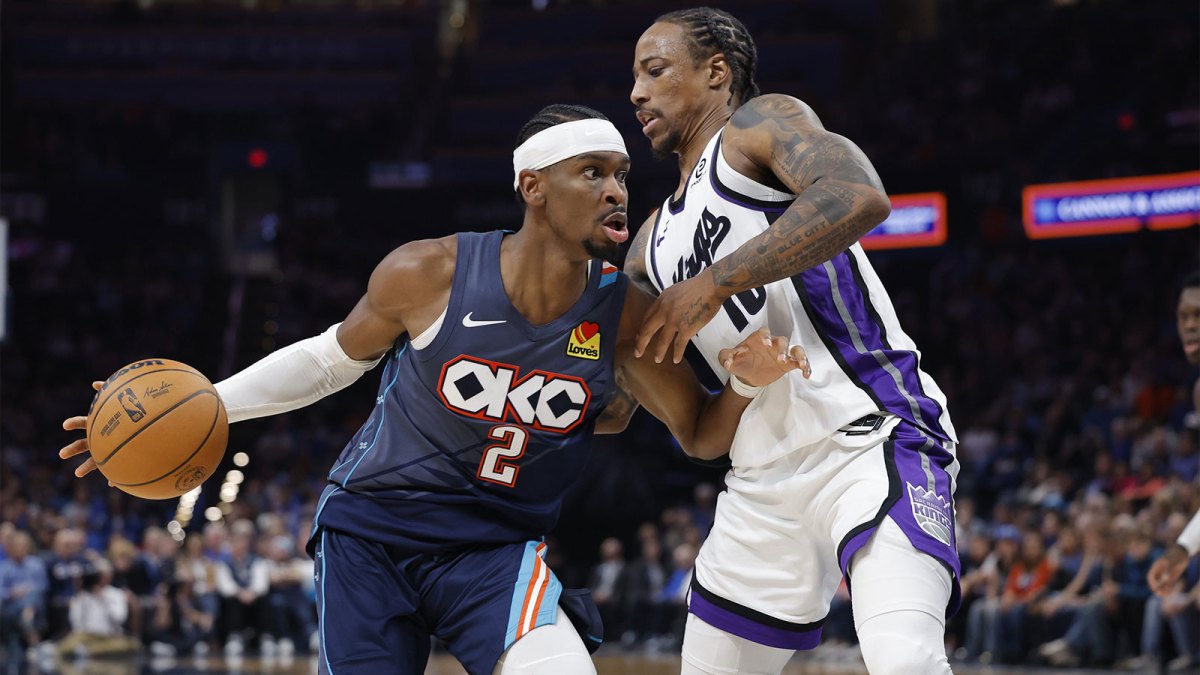 Thunder guard Shai Gilgeous-Alexander (2) moves past Sacramento Kings guard DeMar DeRozan (10) during the second half at Paycom Center with the Nuggets logo in the background