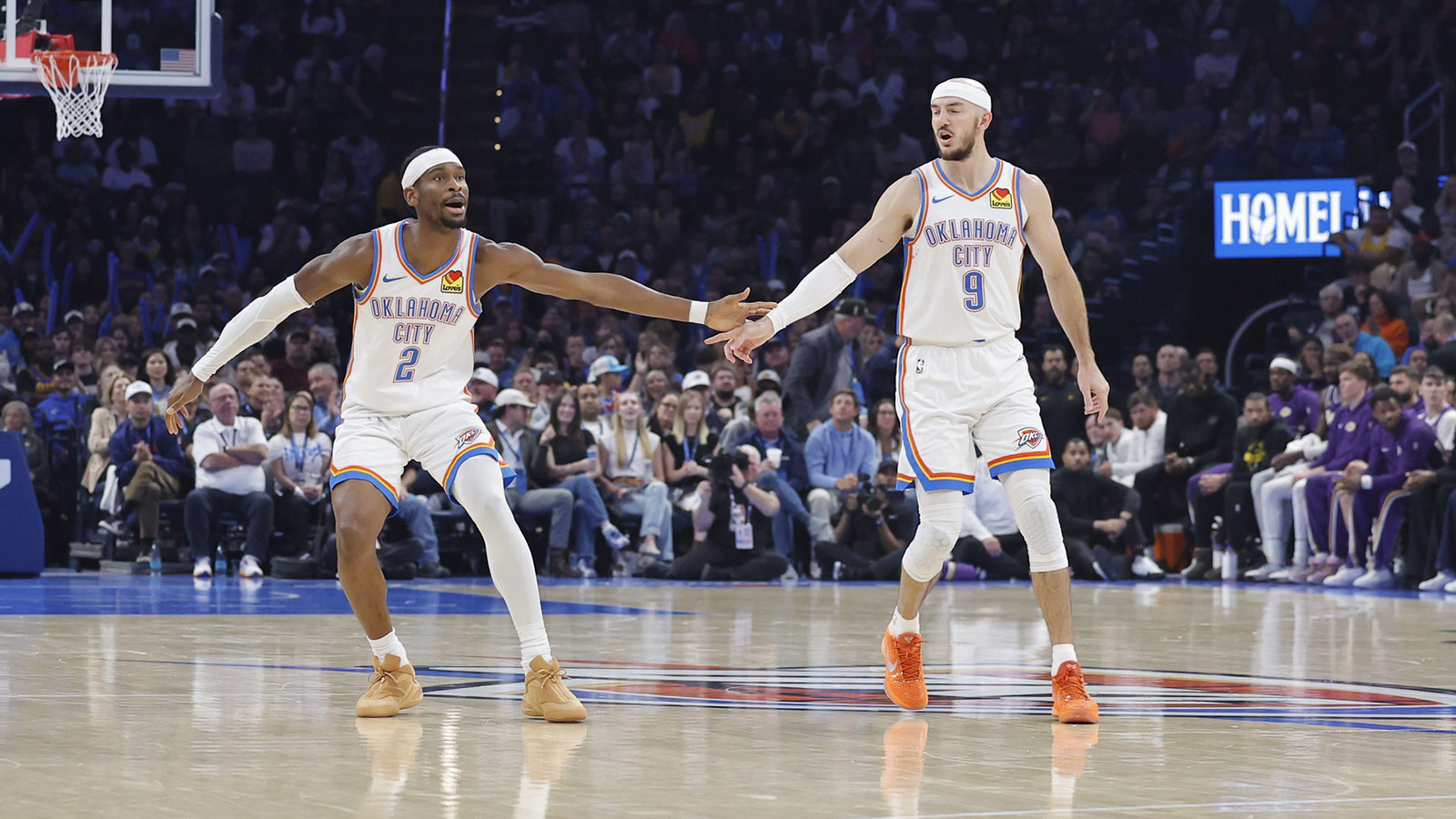 Thunder guard Shai Gilgeous-Alexander (2) and Oklahoma City Thunder guard Alex Caruso (9) celebrate after a basket against the Los Angeles Lakers during the second quarter at Paycom Center