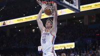 Thunder center Branden Carlson (15) dunks against the Sacramento Kings during the second half at Paycom Center with the Jazz logo in the background