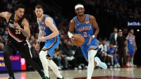 Thunder guard Shai Gilgeous-Alexander (2) dribbles the ball past Portland Trail Blazers forward Toumani Camara (33) as teammate Thunder’s center/forward Isaiah Hartenstein (55) watches during the first half at Moda Center
