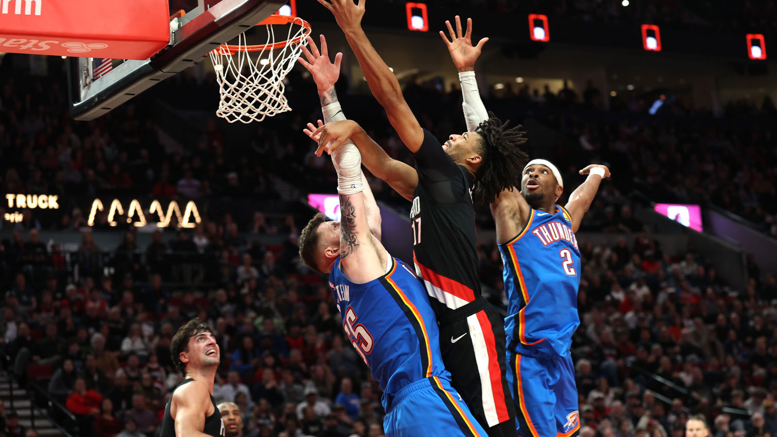 Trail Blazers guard Shaedon Sharpe (17) shoots the ball over Oklahoma City Thunder center/forward Isaiah Hartenstein (55) and guard Shai Gilgeous-Alexander (2) during the second half at Moda Center