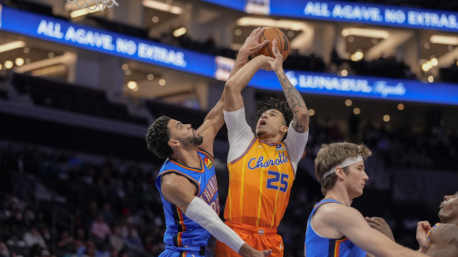 Thunder guard Ajay Mitchell (25) gets a block on the shot by Charlotte Hornets guard Tre Mann (23) during the first half at Spectrum Center