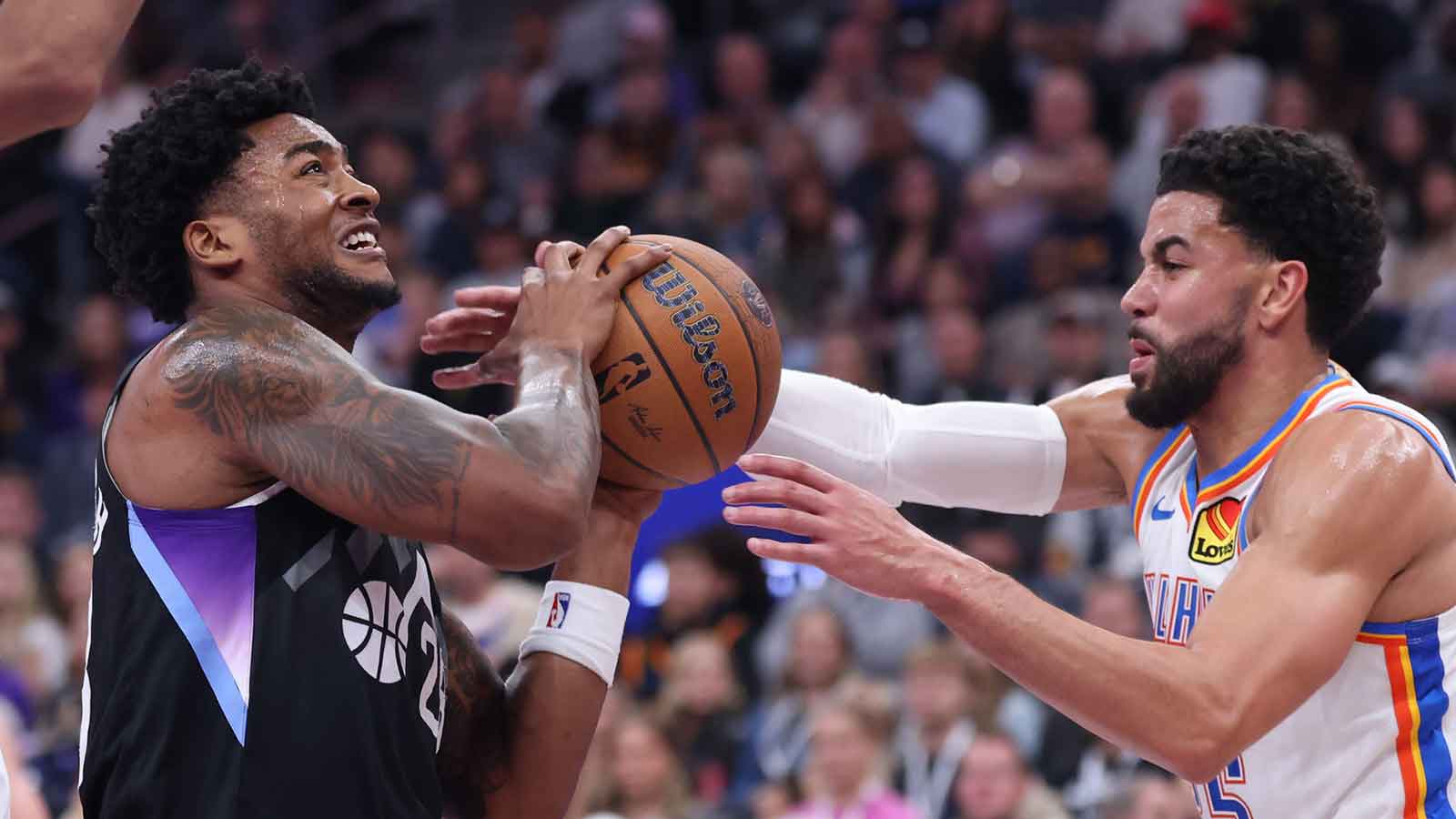 Jazz forward Brice Sensabaugh (28) has the ball knocked away by Oklahoma City Thunder guard Ajay Mitchell (25) during the second half at Delta Center