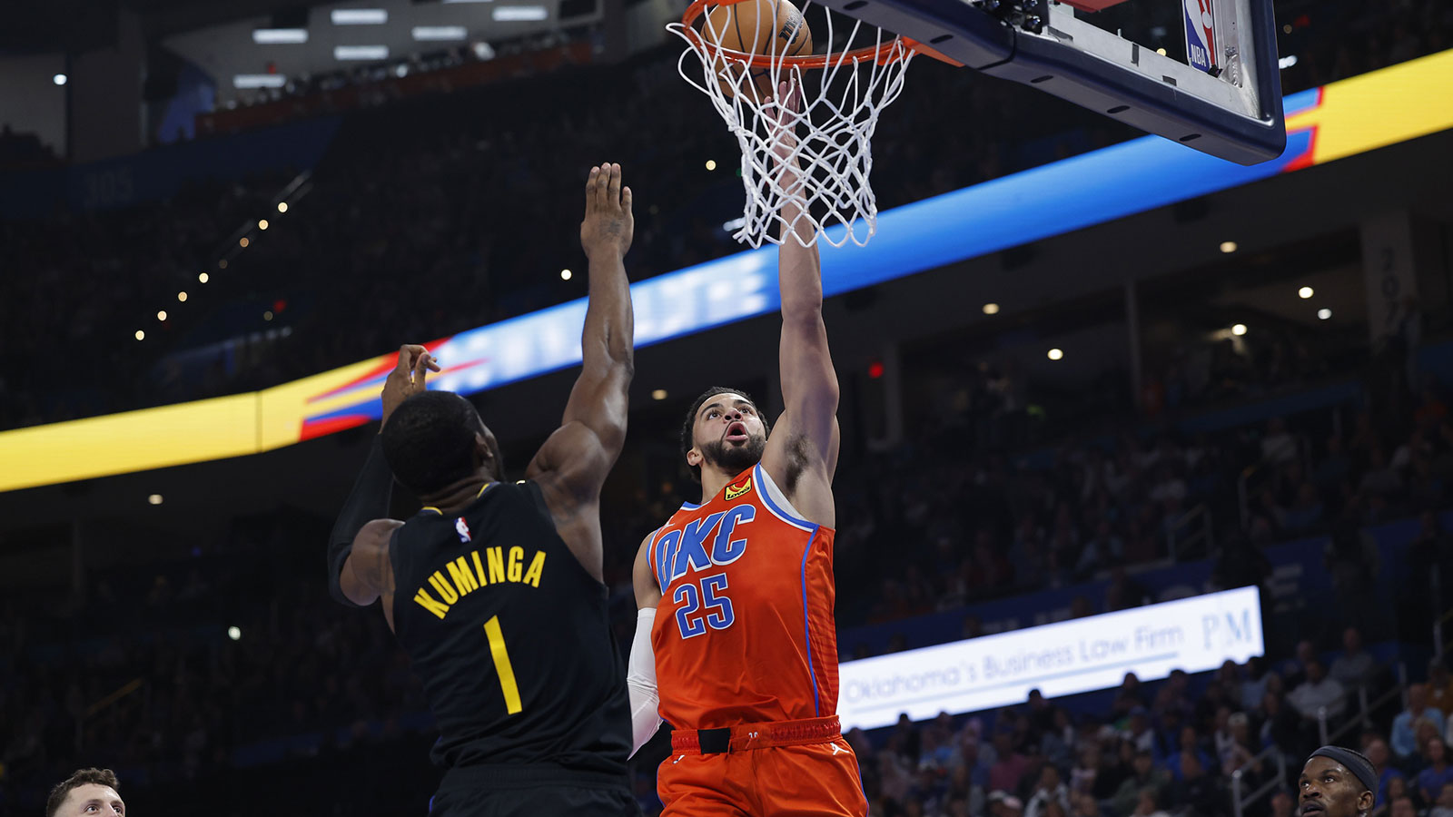 Thunder guard Ajay Mitchell (25) goes up for a basket in front of Golden State Warriors forward Jonathan Kuminga (1) during the second quarter at Paycom Center