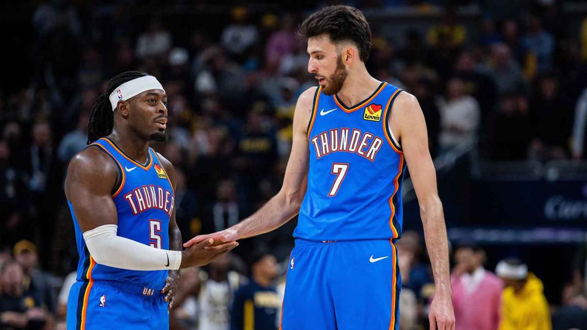 Thunder guard Lu Dort (5) and center Chet Holmgren (7) in the second half against the Indiana Pacers at Gainbridge Fieldhouse with the Hornets logo in the background