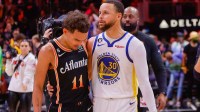 Atlanta Hawks guard Trae Young (11) talks to Golden State Warriors guard Stephen Curry (30) after a game at State Farm Arena.