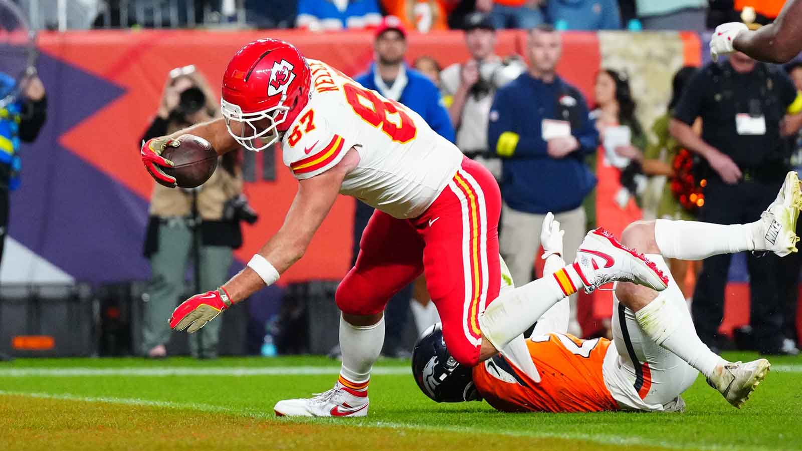 Kansas City Chiefs tight end Travis Kelce (87) scores a touchdown past Denver Broncos cornerback Riley Moss (21) in the fourth quarter at Empower Field at Mile High. 
