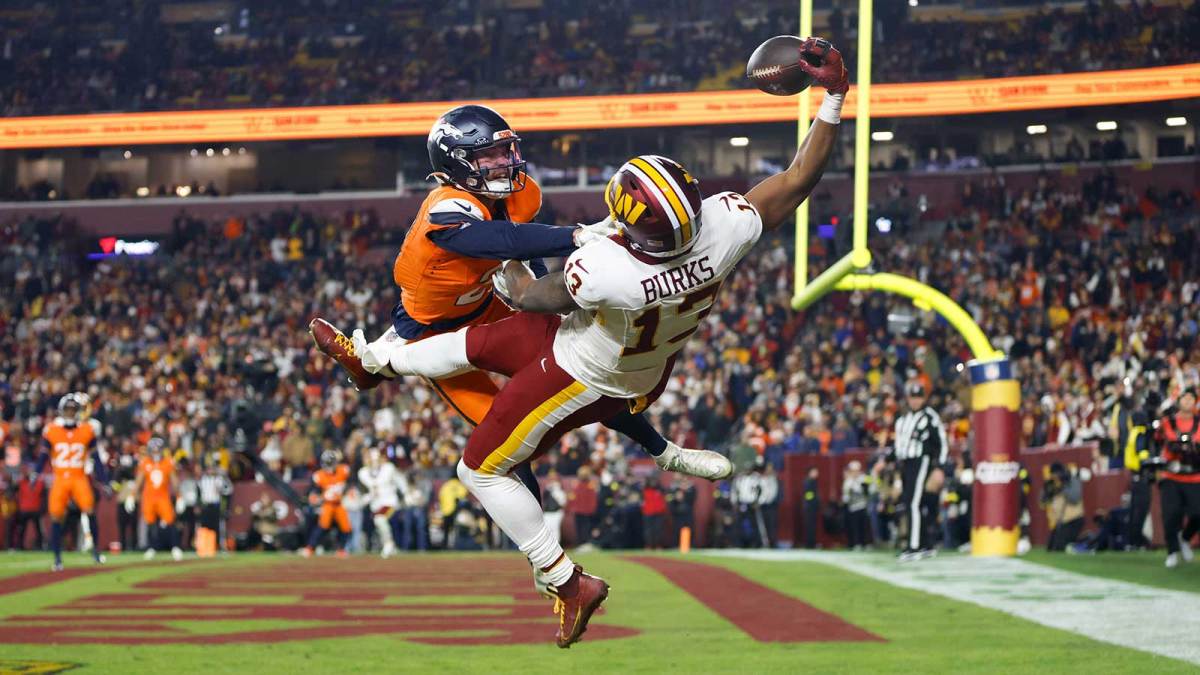 Nov 30, 2025; Landover, Maryland, USA; Washington Commanders wide receiver Treylon Burks (13) makes a catch for a touchdown defended by Denver Broncos cornerback Riley Moss (21) in the third quarter of the game at Northwest Stadium. Mandatory Credit: Peter Casey-Imagn Images