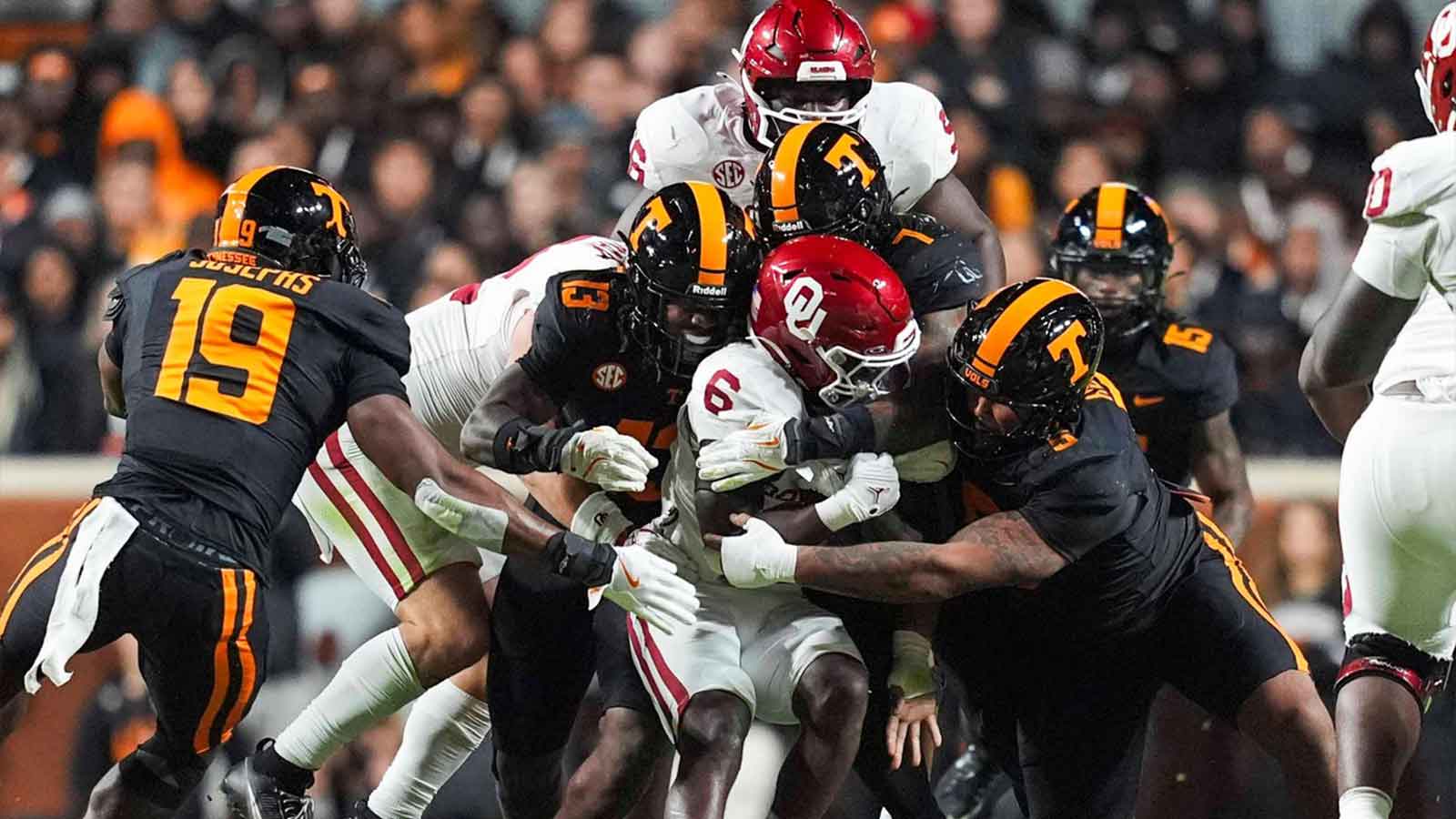 Oklahoma running back Tory Blaylock (6) is warmped by Tennessee linebacker Edwin Spillman (13), Tennessee linebacker Arion Carter (7) and Tennessee defensive lineman Daevin Hobbs (5) during a NCAA football game between the Tennessee Volunteers and Oklahoma Sooners at Neyland Stadium in Knoxville, Tenn., on November 1, 2025.