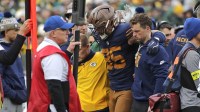 Green Bay Packers tight end Tucker Kraft (85) is assisted off the field after getting injured against the Carolina Panthers during their football game at Lambeau Field.