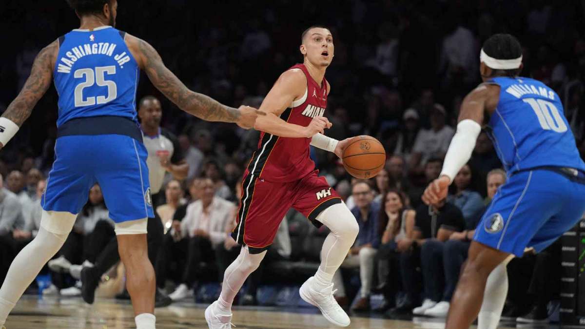 Miami Heat guard Tyler Herro (14) brings the ball up the court as Dallas Mavericks forward P.J. Washington (25) and guard Brandon Williams (10) defend in the first half at Kaseya Center.