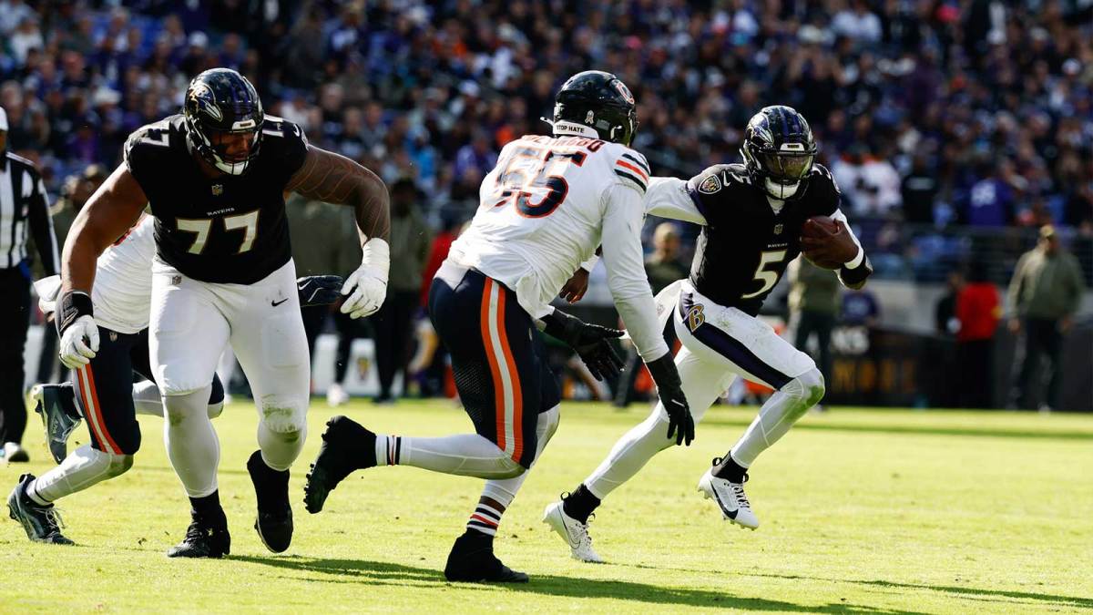 Baltimore Ravens quarterback Tyler Huntley (5) runs with the ball as Chicago Bears defensive end Dayo Odeyingbo (55) chases in the third quarter at M&T Bank Stadium.