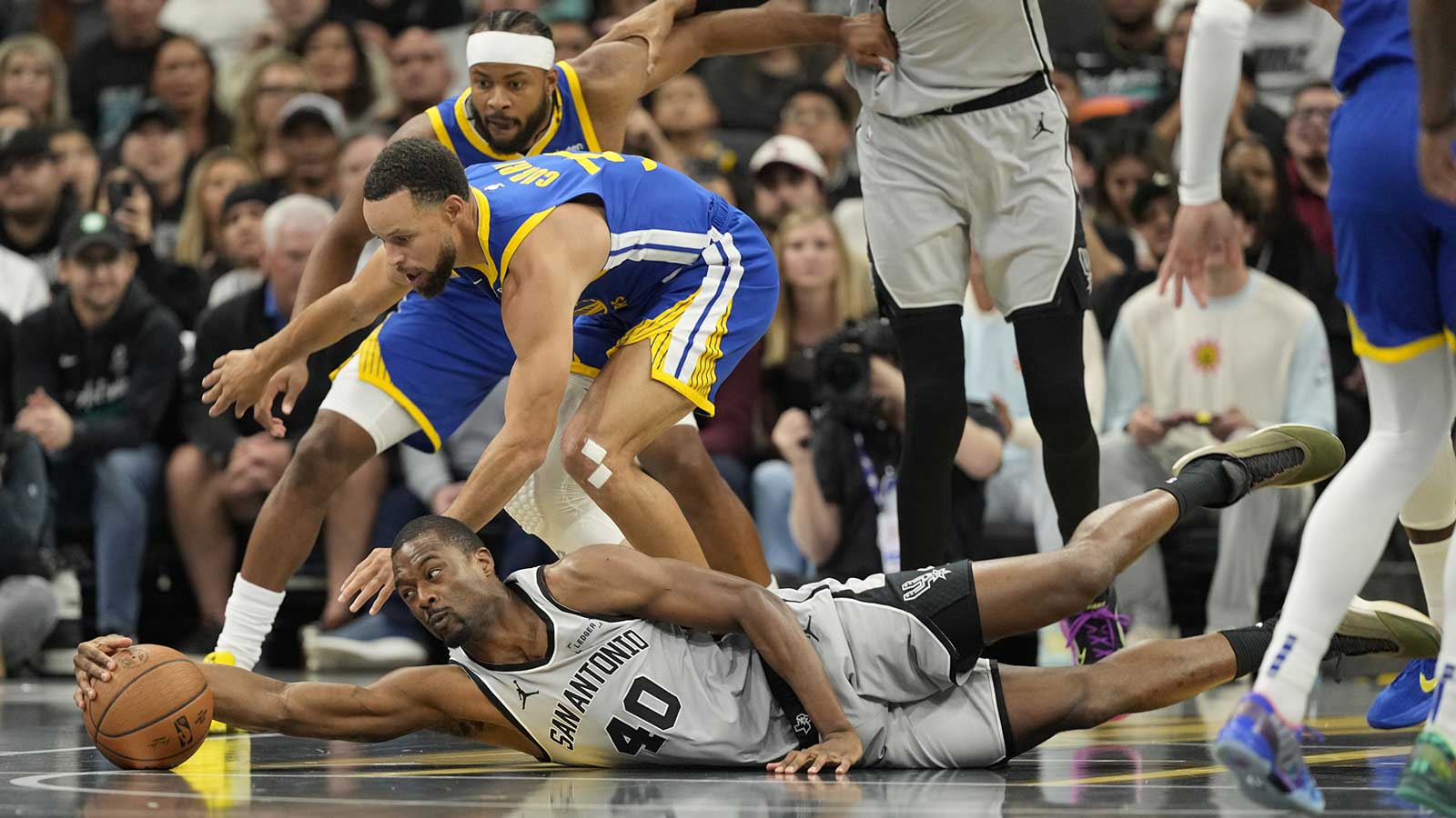 San Antonio Spurs forward Harrison Barnes (40) and Golden State Warriors guard Stephen Curry (30) battle for a loose ball during the first half at Frost Bank Center.