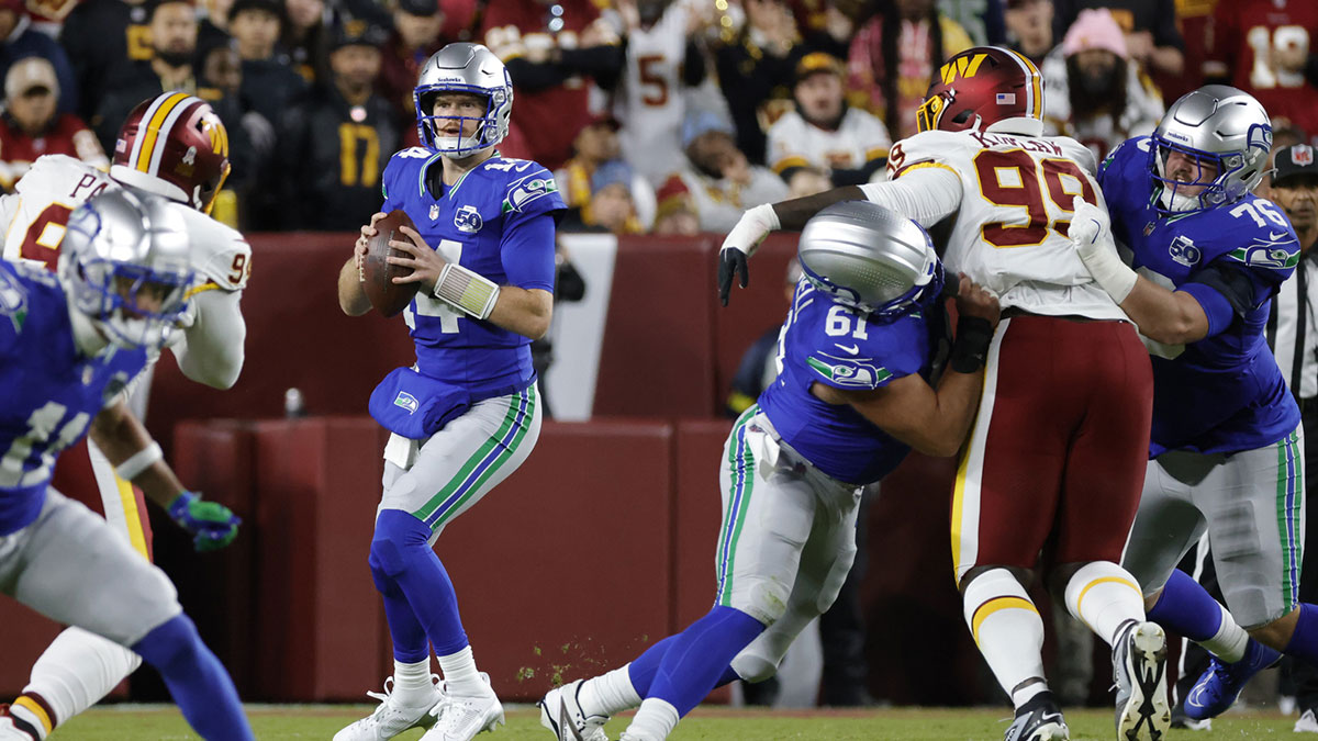 Seattle Seahawks quarterback Sam Darnold (14) looks to pass against the Washington Commanders during the first half at Northwest Stadium.