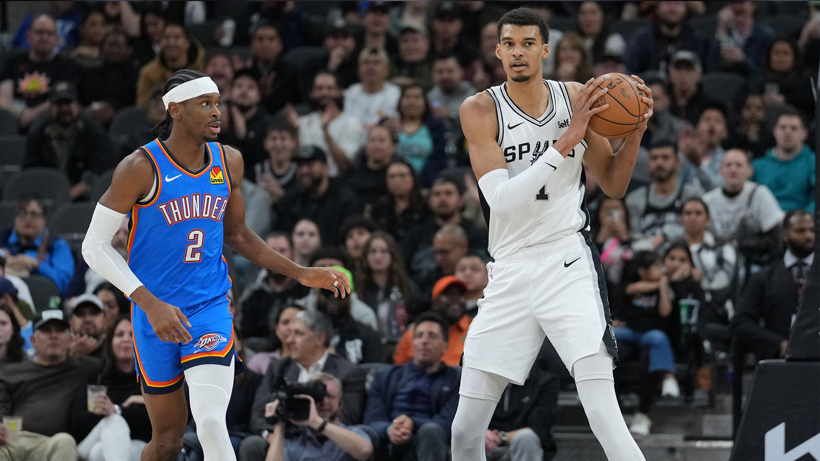 San Antonio Spurs center Victor Wembanyama (1) looks down the court beside Oklahoma City Thunder guard Shai Gilgeous-Alexander (2) in the first half at Frost Bank Center. 