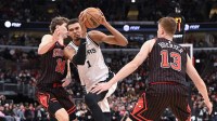 San Antonio Spurs forward Victor Wembanyama (1) drives to the basket against Chicago Bulls forward Matas Buzelis (14) and guard Kevin Huerter (13) during the second half at the United Center.