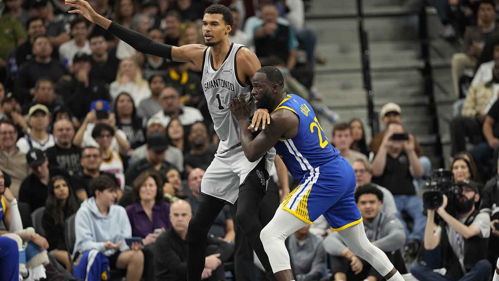 San Antonio Spurs forward Victor Wembanyama (1) posts up on Golden State Warriors forward Draymond Green (23) during the first half at Frost Bank Center.