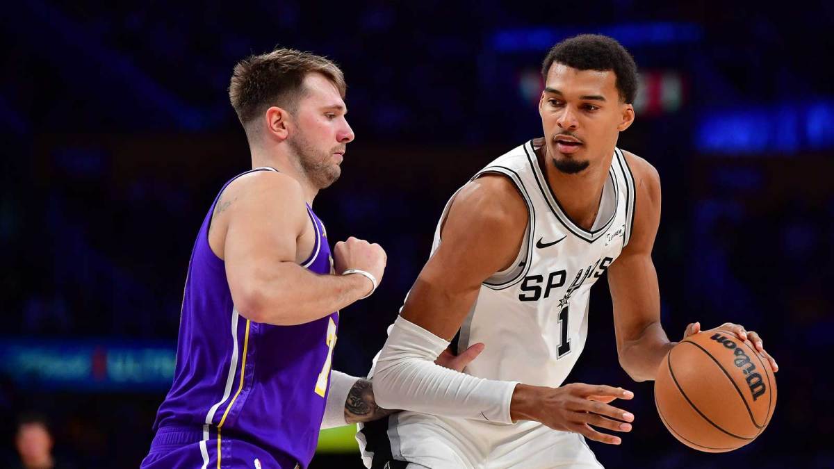 San Antonio Spurs forward Victor Wembanyama (1) moves the ball against Los Angeles Lakers guard Luka Doncic (77) during the second half at Crypto.com Arena.
