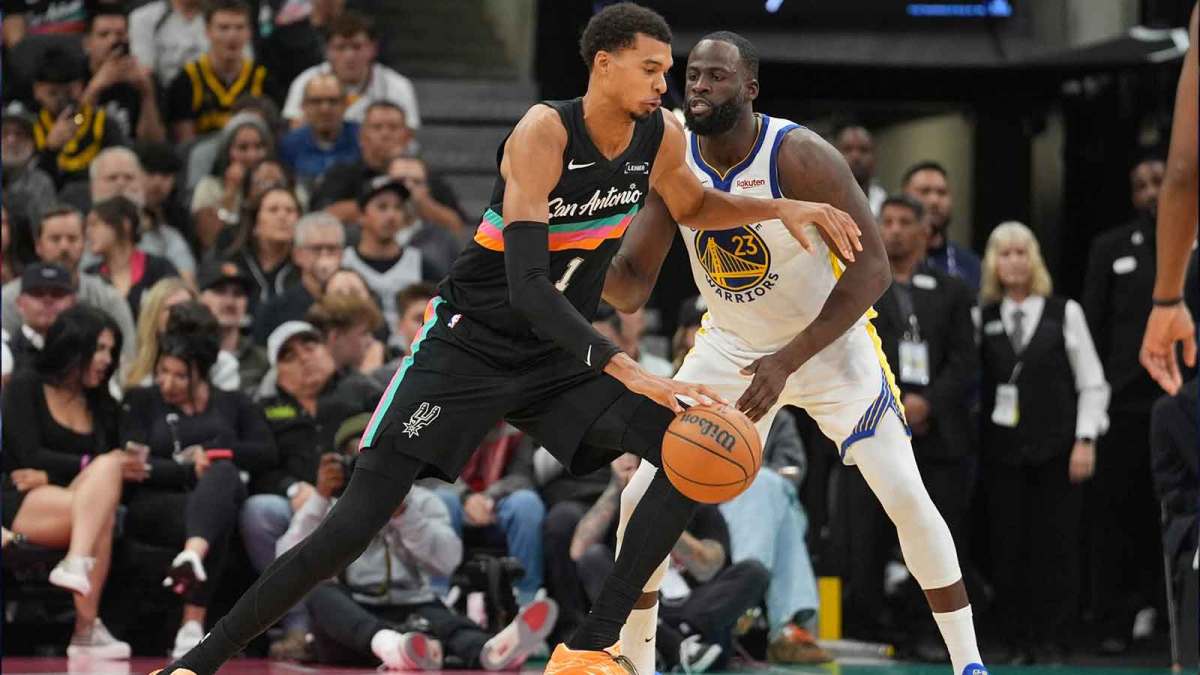 San Antonio Spurs forward Victor Wembanyama (1) dribbles against Golden State Warriors forward Draymond Green (23) in the second half at Frost Bank Center.