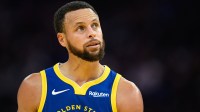 Warriors guard Stephen Curry (30) looks on against the Phoenix Suns in the third quarter at Chase Center with UFC fighter Tracy Cortez in the background