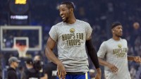 Warriors forward Jonathan Kuminga (1) warms up before facing the Indiana Pacers at Chase Center with the Pelicans logo in the background