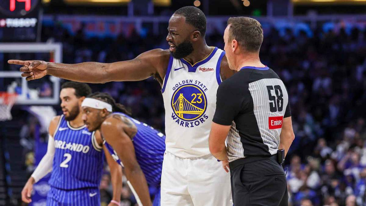 Warriors forward Draymond Green (23) speaks with referee Josh Tiven (58) during the second quarter against the Orlando Magic at Kia Center with Kenyon Martin in the background