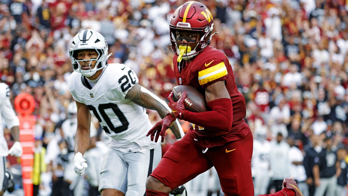 Washington Commanders wide receiver Terry McLaurin (17) runs the ball during the second half as Las Vegas Raiders safety Isaiah Pola-Mao (20) defends at Northwest Stadium.