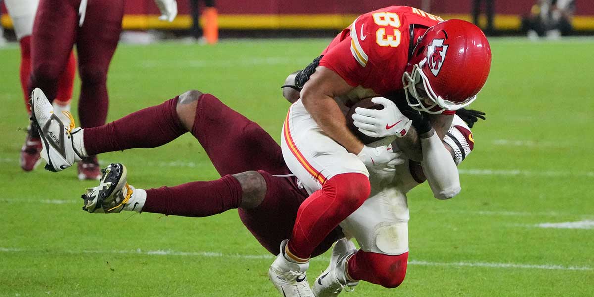 Washington Commanders linebacker Frankie Luvu (4) tackles Kansas City Chiefs tight end Noah Gray (83) during the fourth quarter of the game at GEHA Field at Arrowhead Stadium.