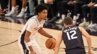 San Antonio Spurs guard Dylan Harper (2) brings the ball down court as Phoenix Suns guard Collin Gillespie (12) defends during the first half of a game at PHX Arena.