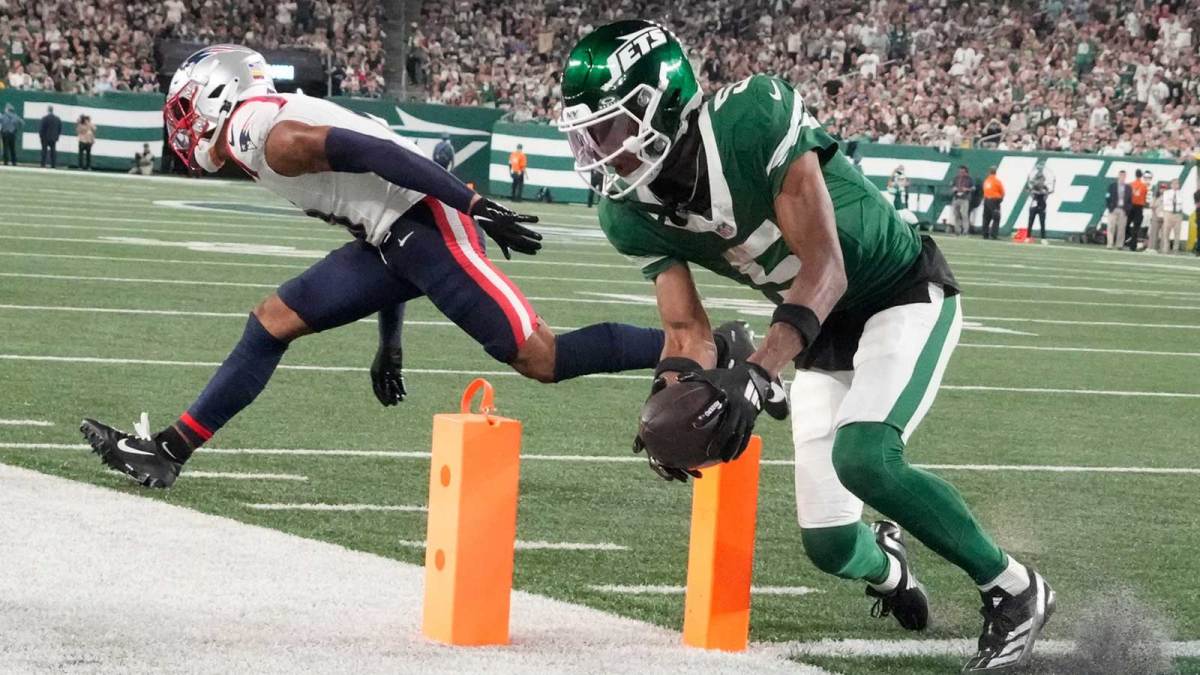 New York Jets wide receiver Garrett Wilson (5) scores a 3rd quarter touchdown in front of New England Patriots cornerback Christian Gonzalez (0) at MetLife Stadium.