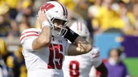 Wisconsin Badgers quarterback Hunter Simmons (15) covers his ears in the first half against the Michigan Wolverines at Michigan Stadium.