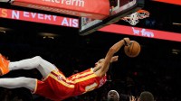 Atlanta Hawks forward Zaccharie Risacher (10) reacts while in the air after a slam dunk that caused him to flips backwards after holding onto the rim for too long during the second half of a game against the Phoenix Suns at Mortgage Matchup Center.