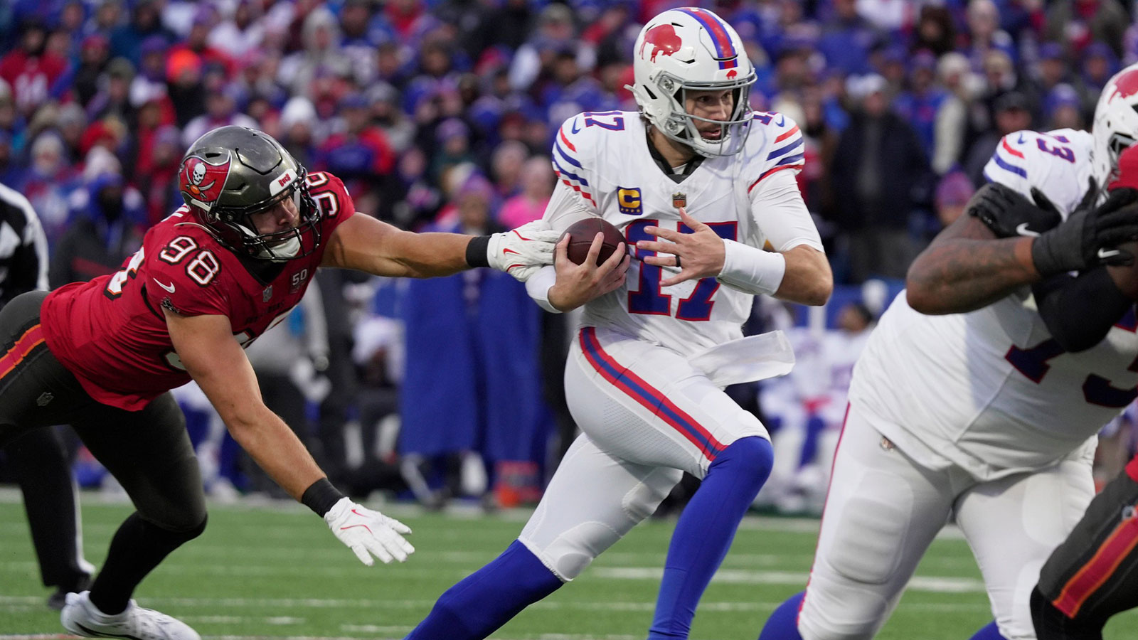 Buffalo Bills quarterback Josh Allen avoids Tampa Bay Buccaneers linebacker Anthony Nelson and runs for his third touchdown of the game during second half action against the Tampa Bay Buccaneers on Nov 16, 2025 at Highmark Stadium in Orchard Park.