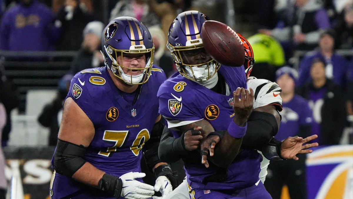 Bengals Joseph Ossai (58) helps take down Ravens Lamar Jackson (8) for the Bengals to take the ball during their game against the Ravens at M&T Bank Stadium on Thanksgiving Thursday November 27, 2025.