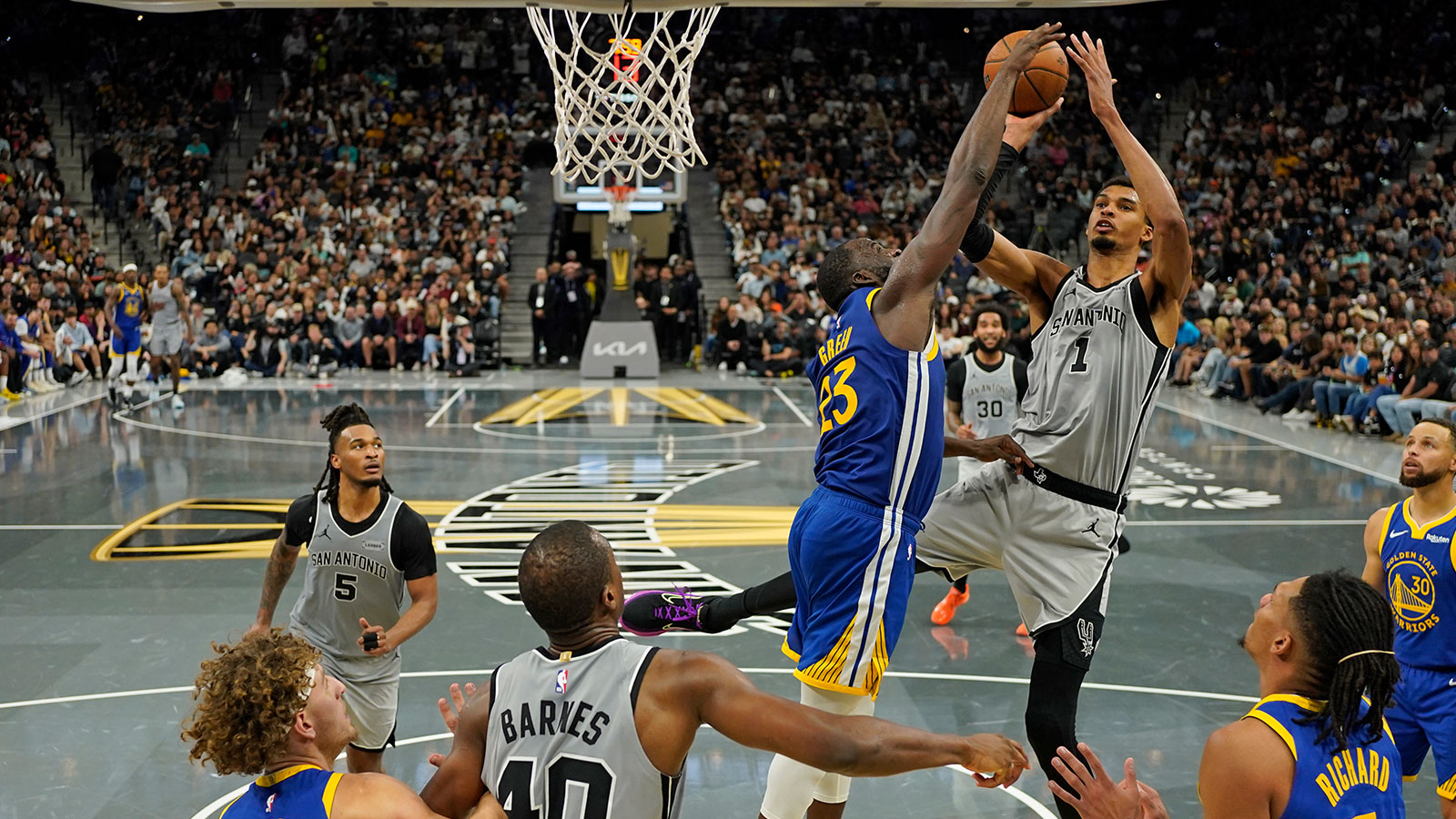 San Antonio Spurs forward Victor Wembanyama (1) shoots over Golden State Warriors forward Draymond Green (23) during the second half at Frost Bank Center.