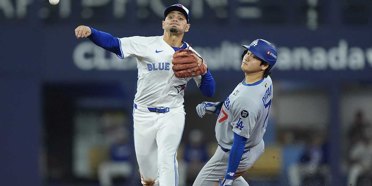 Toronto Blue Jays shortstop Andres Gimenez (0) turns a double play against Los Angeles Dodgers two-way player Shohei Ohtani (17) and first baseman Freddie Freeman (5) in the seventh inning during game seven of the 2025 MLB World Series at Rogers Centre.
