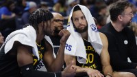 Golden State Warriors guard Buddy Hield (7) and guard Stephen Curry (30) talk on the bench during the second half against the Oklahoma City Thunder at Paycom Center.