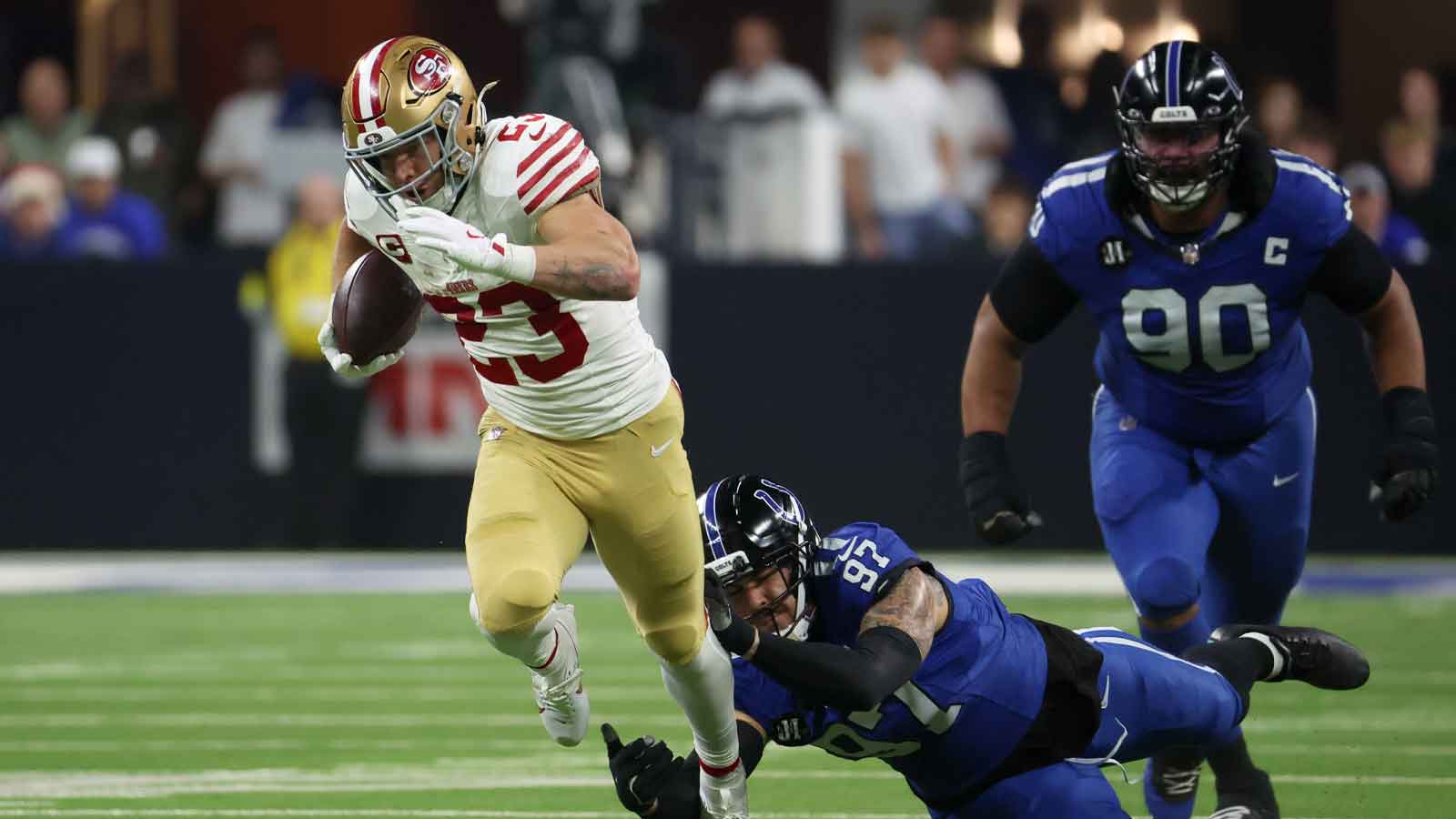 San Francisco 49ers running back Christian McCaffrey (23) avoids a tackle by Indianapolis Colts defensive end Laiatu Latu (97) in the second quarter of the game at Lucas Oil Stadium.