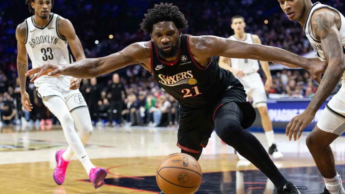 Philadelphia 76ers center Joel Embiid (21) lunges for a loose ball in front of Brooklyn Nets forward Noah Clowney (21) during the fourth quarter at Xfinity Mobile Arena.