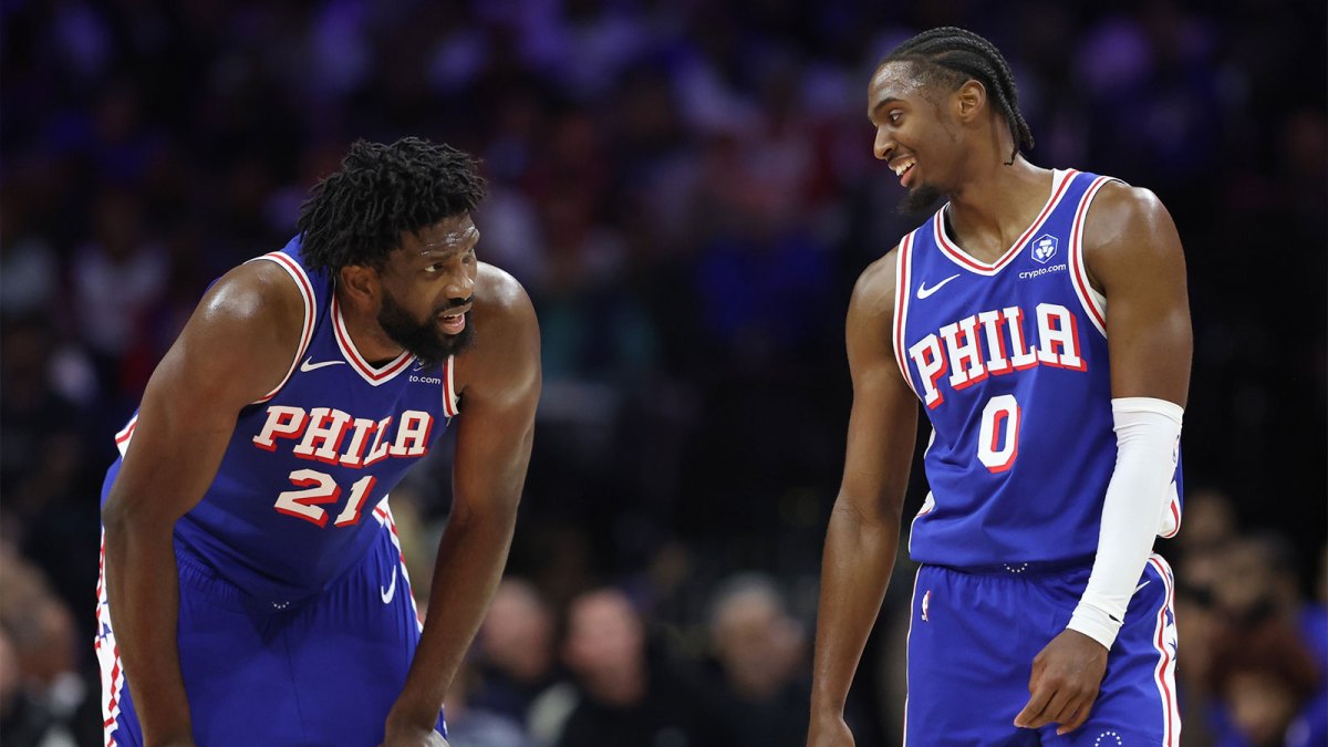 Philadelphia 76ers guard Tyrese Maxey (0) and center Joel Embiid (21) talks during a break in action in the second quarter against the Charlotte Hornets at Xfinity Mobile Arena.