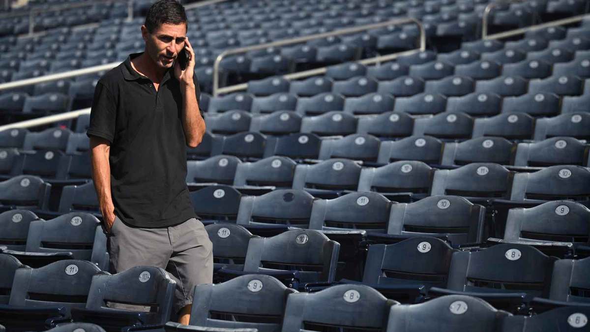 San Diego Padres general manager AJ Preller speaks on the phone during NLCS workouts at Petco Park.