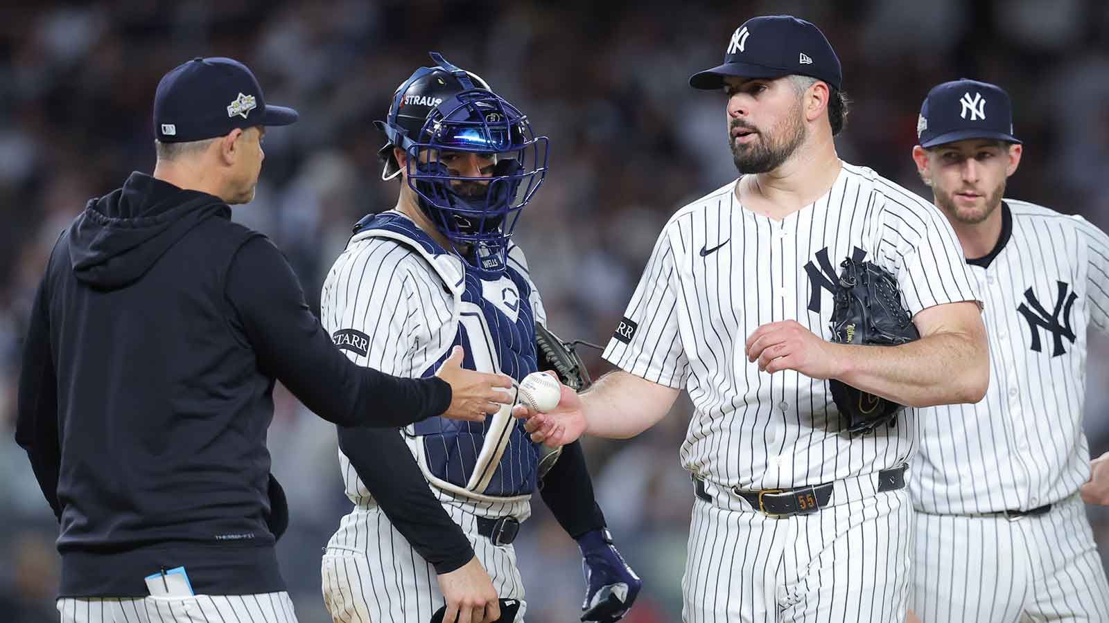 New York Yankees starting pitcher Carlos Rodon (55) leaves the mound as New York Yankees manager Aaron Boone (17) makes a pitching change during the seventh inning against the Boston Red Sox during game two of the Wildcard round for the 2025 MLB playoffs at Yankee Stadium. 