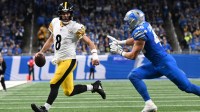 Pittsburgh Steelers quarterback Aaron Rodgers rushing with Detroit Lions linebacker Jack Campbell next to him.